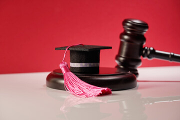 Gavel with mortarboard on the table.