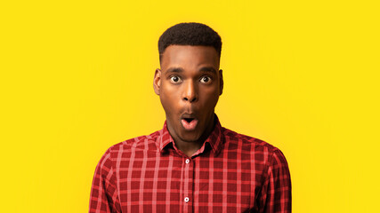 Fototapeta premium Portrait Of Surprised African American Guy Opened Mouth In Amazement, Shocked Black Millennial Man Looking Stunned And Impressed, Emotionally Reacting To News Over Yellow Background, Free Space