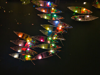 Aerial shot of Hoi An at night with lanterns floating on the river, tourists walking the streets, and boats creating a festive atmosphere. Great for cultural and travel media © Nhut