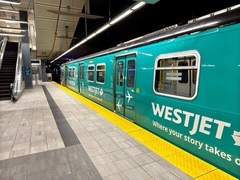 SkyTrain metro station in Vancouver, WestJet-branded train, lit platform &ndash; JackCA, stock.adobe.com