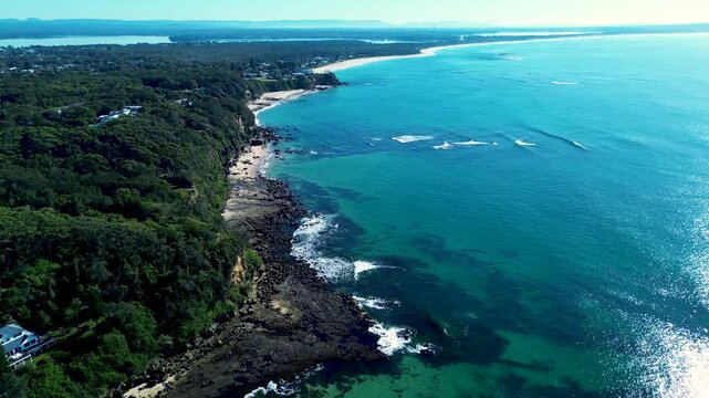 Drone aerial landscape of waves breaking on ocean reef on Norah Head beach and Jenny Dixon Reserve with ocean coastline headland in rural suburban town Central Coast Australia vacation nature tourism
