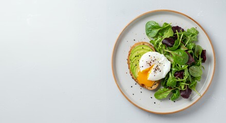 Indulge in a vibrant avocado toast topped with a perfectly poached egg and a fresh mix of greens.