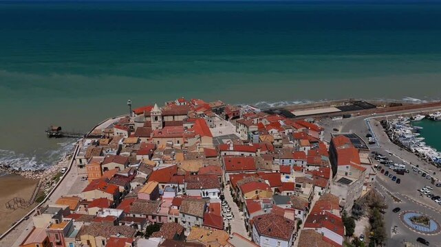 Aerial view of Termoli medieval old town with colorful rooftops, cathedral, square. Sandy beaches and sea.