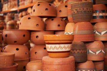 Ceramic pottery pots with different designs stacked for sale in Raquira, Boyaca, Colombia, a tourist town known for its handmade ceramic products.