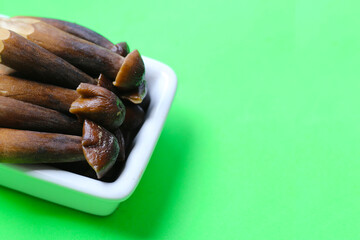 Termite mushrooms with long stems, white tips, and dark brown caps.