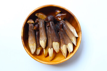 Termite mushrooms with long stems, white tips, and dark brown caps.