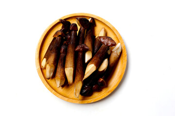 Termite mushrooms with long stems, white tips, and dark brown caps.