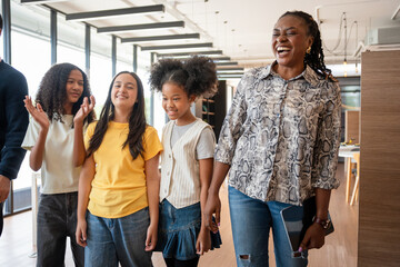 Adult Professionals Guiding and Interacting with Young People in a Contemporary Setting, Diverse...