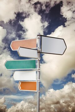 Fototapeta Multi colored sign posts against cloudy sky