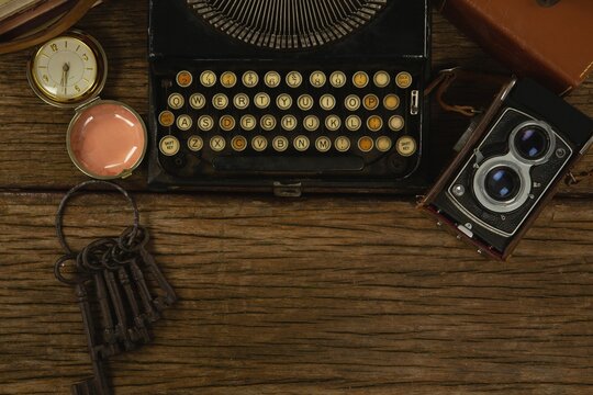 Typewriter, camera and clock on table