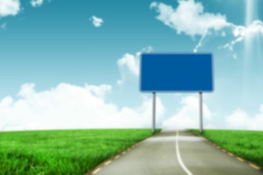 Blue billboard on raod by grassy field