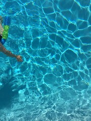Child Swimming in Sunlit Pool