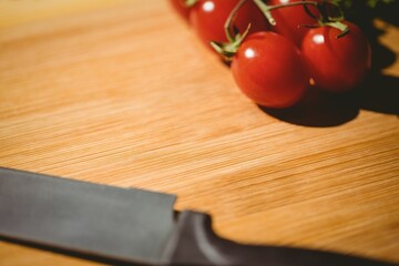 Tomatoes and knife on chopping board