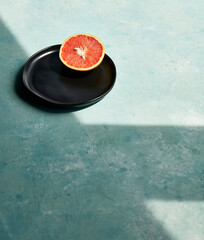 Half Grapefruit on Black Plate in Dramatic Light