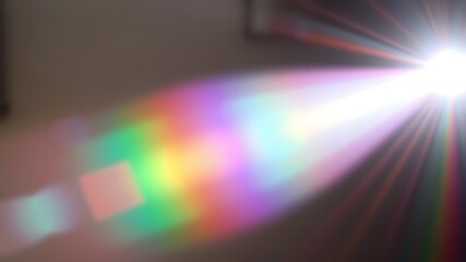 Abstract lens flare with prismatic effect of rainbow spectrum radiating vibrant colors from bright light source.
