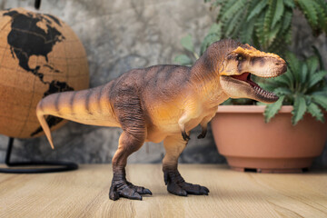 T-rex Dinosaur toy. Tyrannosaurus rex with Dorstenia Plant in plastic pot simulate and mini globe...