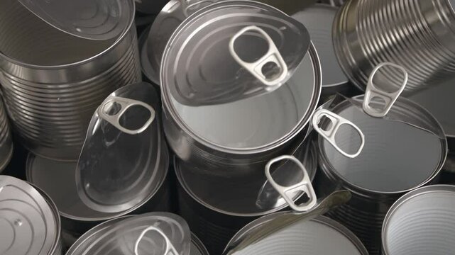 Reflective aluminum cans aligned in rows glisten under soft studio lighting as a smooth top-down camera glides forward, enhancing metallic texture and depth.