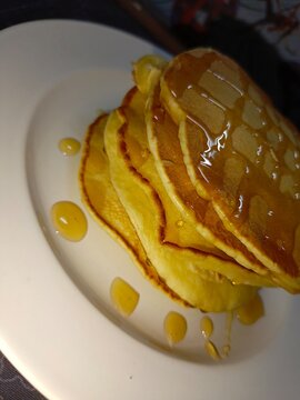 Pancake on a white plate with honey topping