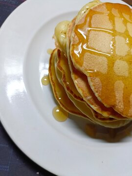 Pancake on a white plate with honey topping