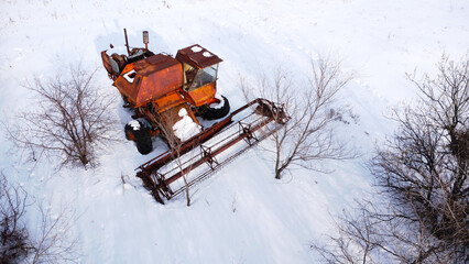 Old broken harvester abandoned in snowed countryside