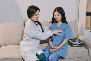 A doctor uses a stethoscope to check the heartbeat of his patient. Patients must undergo a yearly...
