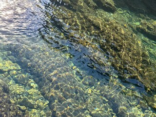 Stones pebbles gravel in crystal clear water.