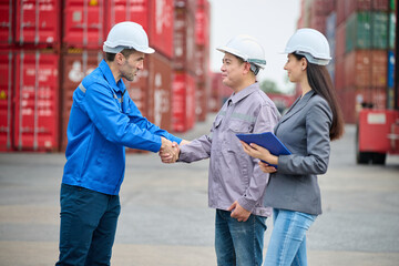 Engineers or workers shaking hands in containers warehouse storage
