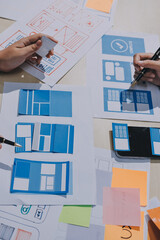 Group of young application developers analyzing uxui mobile app templates during a working meeting
