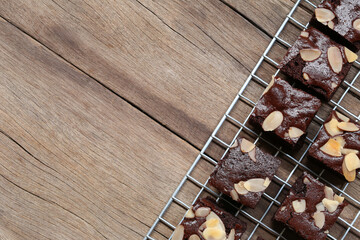 Deliciously Rich Chocolate Brownies with Almonds Sitting on a Cooling Rack Against a Rustic Wooden Background for Perfect Dessert Photography
