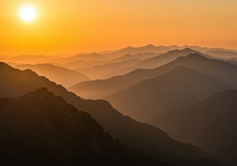 Fototapeta premium A breathtaking sunset illuminates layers of hazy mountains creating a stunning landscape