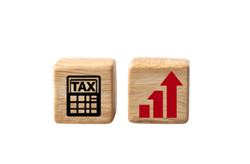 A wooden block with the word TAX on it and an icon of a calculator beside that cube.