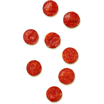 A collection of round slices of pepperoni arranged on a white background.