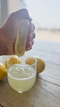 Hand Squeezing Fresh Lemon Juice.