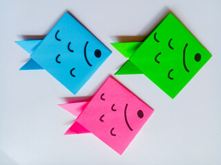 Blue, pink and green fish origami isolated on white background.