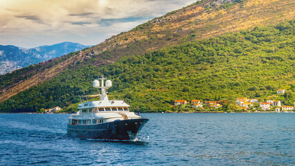 Luxury superyacht cruising on the serene blue waters of the stunning Bay of Kotor in Montenegro,...