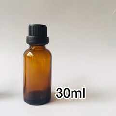 Small 30ml amber essential oil bottle on white background