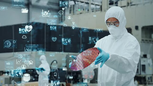 Digital technology concept with worker in protective suit inspecting semiconductor wafer in factory