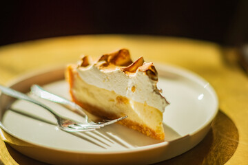Delicious cake slice featuring layers of cream and meringue, elegantly placed on a simple dish