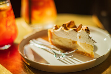 Indulge in a rich cream pie alongside vibrant drinks in a warm and inviting cafe atmosphere