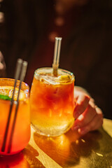 Sipping on colorful cocktails with friends as the warm sunlight enhances the vibrant atmosphere