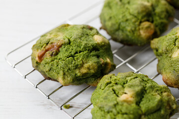 Closeup of fresh baked matcha cookies on white wooden background.