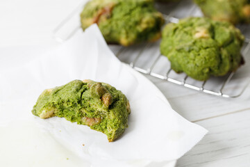 Closeup of fresh baked matcha cookies on white wooden background.