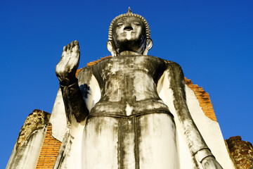 Majestic Buddha Statue Against Clear Blue Sky in Historic Setting