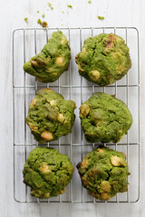 Closeup of fresh baked matcha cookies on white wooden background.