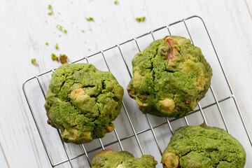 Closeup of fresh baked matcha cookies on white wooden background.