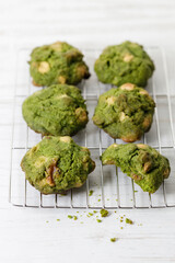 Closeup of fresh baked matcha cookies on white wooden background.