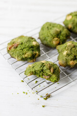 Closeup of fresh baked matcha cookies on white wooden background.