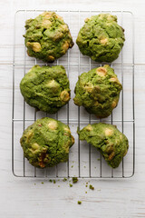 Closeup of fresh baked matcha cookies on white wooden background.