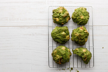 Closeup of fresh baked matcha cookies on white wooden background.