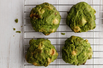 Closeup of fresh baked matcha cookies on white wooden background.